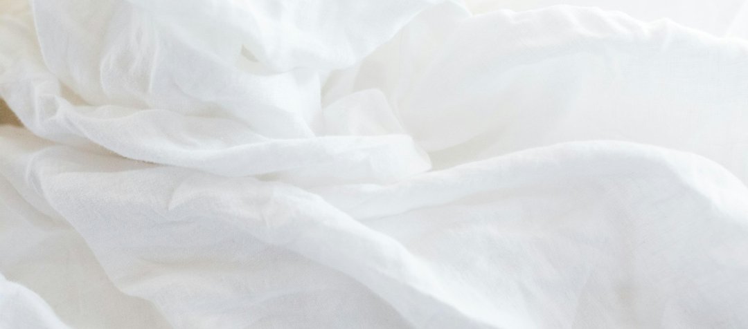 Housse de couette en coton blanc froissé sur un lit
