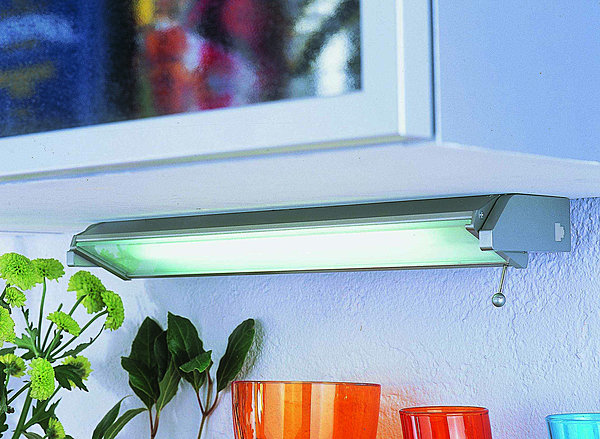Fixée sous un meuble haut, l'applique fluo est inclinable et orientable. Hygena.