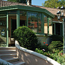 En appui en façade, cette véranda affiche une couleur verte qui rappelle celle de la nature environnante. Reynaers.