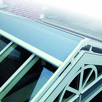 Intégré à la structure de la véranda, le store à enroulement permet une gestion efficace de l'ensoleillement. Reynaers.