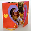 Le cadre cœur décoré avec des fleurs et 2 cœurs en papier.`