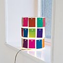 Un luminaire grillagé recouvert de petites cartes en papier crêpon