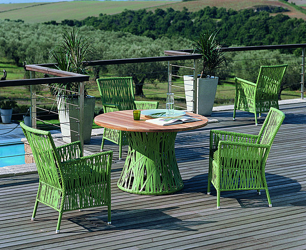 Structure en aluminium et fibres en polyéthylène au tressage original pour cette collection qui comprend une table à plateau en teck et de petits fauteuils. Table H 73 x 120 cm. Fauteil 69 x 60 x H 91 cm. Kentia. Unopiu.