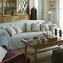 Sur la table basse devant le canapé Flamant, accessoires CFOC, photophores Flamant, coussins Pierre Frey. Au fond une imposante bibliothèque anglaise offre lecture et jeux de société à tous les habitants vacanciers.