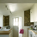 Afin d’en conserver l’aspect authentique, la cuisine a été dallée de pavés anciens et les murs de pierres sèches ont été conservés. Les meubles de cuisine dessinés par Aude ont été réalisés sur mesure. Panier blanc Opportunity, sac fushia Descamps.