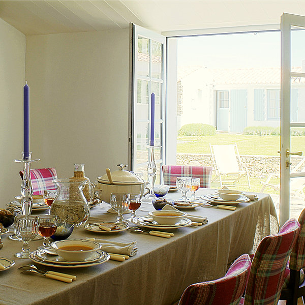 La salle à manger est ouverte sur le jardin, la table en pin a été chinée dans une brocante