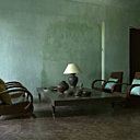 Dans le salon du bâtiment bleu aux murs délavés, coussins en soie turquoise Tendance Khmère