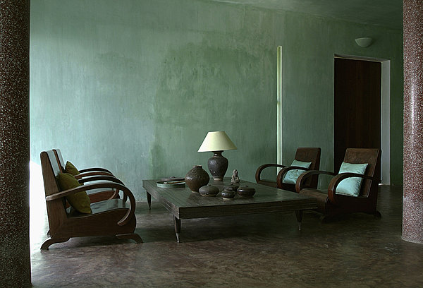 Dans le salon du bâtiment bleu aux murs délavés, coussins en soie turquoise Tendance Khmère