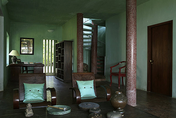 Dans le salon du bâtiment bleu aux murs délavés, coussins en soie turquoise Tendance Khmère