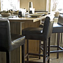 Sur la table toutes les matières sont présentent, la porcelaine Raynaud, les verres Ex-Sud et Bleu Nature, les couverts Sabre, le lin Alexandre Turpault. Les chaises hautes Peggy Bauwens entourent la table