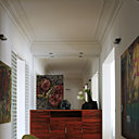 La grande entrée se prolonge par un meuble en bois de pommier indien surmonté d’un miroir qui agrandit l’espace. Rocking chair RAR Charles & Ray Eames chez Galerie Sentou, vases Coming B, Office Hollandais des fleurs, peinture Rodrigo Xicotencatl