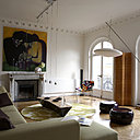 La blancheur du sol et des murs du salon contribue à magnifier l’espace. Grand lampadaire Céline Wright