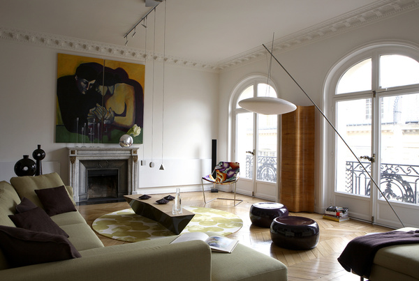 La blancheur du sol et des murs du salon contribue à magnifier l’espace. Grand lampadaire Céline Wright