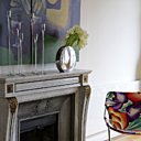 Pouf en laque Ekobo, fauteuil Missoni-Objekto chez Sentou Galerie, sur la cheminée bougeoirs Blf, vase Coming B, fleurs Office Hollandais