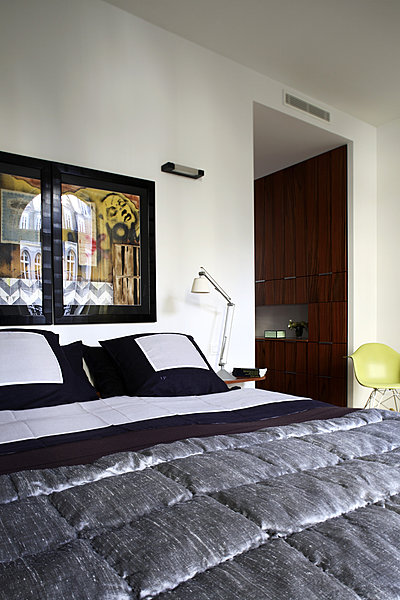 La chambre des parents ouverte sur le grand dressing et la salle de bain est isolée du reste de l’appartement. Draps Eden Park, boutis Tendance Khmere, fauteuil DAX par Charles & Ray Eames