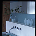 Lavabo double en verre thermoformé avec bac central, sur un support en aluminium Exsud, bouteilles en verre soufflé Exsud, produits de bain Lhotentique