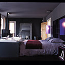 La vaste chambre de Charlotte et Albrecht donne directement sur la salle de bain. Chevets, luminaires, tête de lit capiton et lavabo Exsud, draps lin rayé et serviettes éponge Eden park, plaid prune Linum