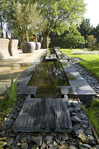 Fontaine et bassin maçonné sur mesure en ciment noir et dallage d'ardoise