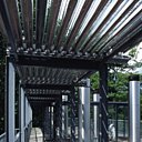 Sur le toit de la demeure, la juxtaposition de portiques en métal supporte une importante tuyauterie et plusieurs batteries de cylindres en verre borosilicaté