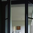 Les sticks lumineux Ugarit encadrent le canapé, sur la table basse en laque de Chine grosse coupe en cristal sable Anna Torfs