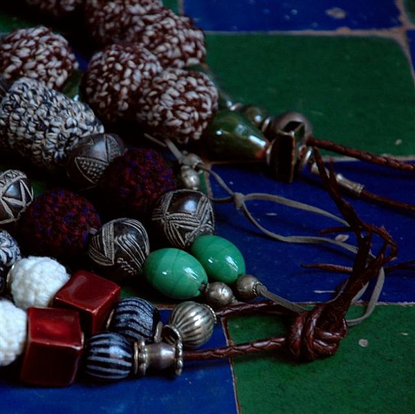 Perles anciennes, en laine et liens de cuir.