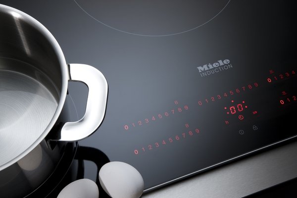 Sur cette table de cuisson chaque zone se voit attribuer une commande spécifique digitale et rétro éclairée.  Table à induction KM6350. Miele.