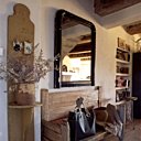 Le banc ancien en pin, délavé par les ans, est surmonté d’un miroir chiné aux puces, sur la console, pot en grès et branche d’olivier Le banc ancien en pin, délavé par les ans, est surmonté d’un miroir chiné aux puces, sur la console, pot en grès et branche d’olivier