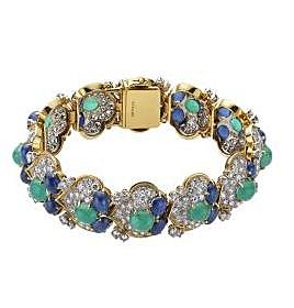 Bracelet en or jaune, émeraudes, saphirs et diamants, circa 1960, représentant une succession de douze palmettes, chacune composée d’une émeraude et deux saphirs en cabochon entourés d’un pavage de diamants