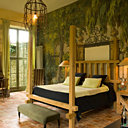 Un grand décor peint sert de toile de fond dans la chambre de l'orangerie