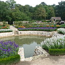 Bordé de fleurs entourées de buis taillés, le bassin central du potager