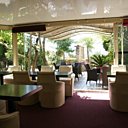 La véranda donne sur une jolie terrasse arborée