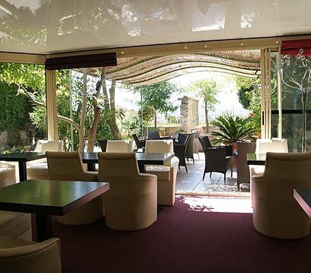 La véranda donne sur une jolie terrasse arborée