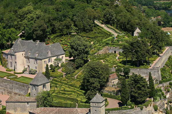Le château au toit de lauzes est au centre des jardins