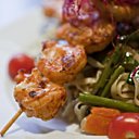 Brochette de crevettes au saté, nouilles sautées aux légumes croquants Brochette de crevettes au saté, nouilles sautées aux légumes croquants
