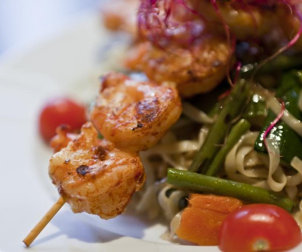 Brochette de crevettes au saté, nouilles sautées aux légumes croquants