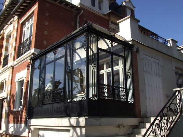 Une véranda en toiture arrondie agrémente le corps du bâtiment