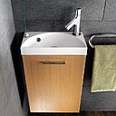 Un meuble lave-mains à l’originale vasque en forme de demi-lune. En marbre de synthèse. Mobalpa.