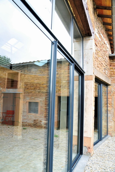 La lumière pénètre par de grandes baies coulissantes à profilés aluminium