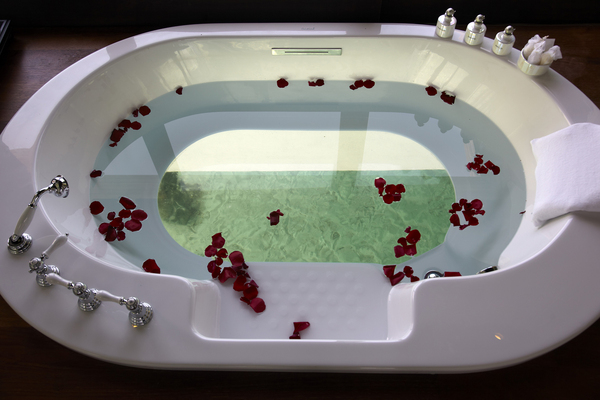 Le fond transparent de la baignoire permet de voir les poissons nageant dans l'eau turquoise