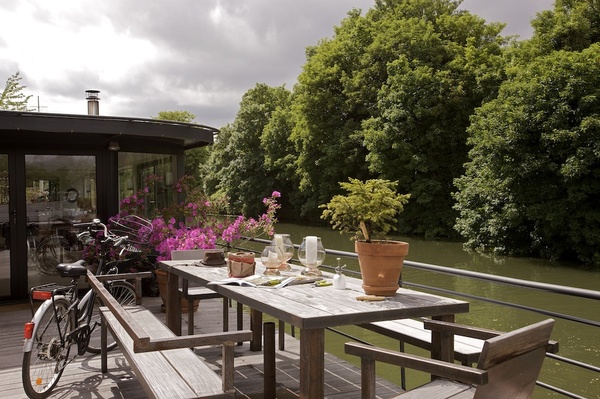 En bord de Seine, une grande terrasse pour savourer de délicieux repas entre amis. Fauteuil, bancs et table, Evasion55, kit de jardinage et chapeau, Nature&Découvertes.