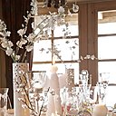 Une symphonie de blancs : vase à bec, Coming’B, vases « Antartic », fleurs de pommier,  Crystal Piquet, Sia, photophores rouge et verres, Potiron, bougies boules blanches et anges, Bougies La Francaise, assiettes et coupelles « Corola, « Esprit de fabrique » pour Olivades, chemin de table, « fleurs vaporeuses », Arielle Dequevauviller pour Collection Maison.