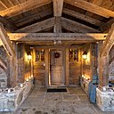 Une entrée digne d’un hôtel 4 étoiles, mélange de pierre de Combloux et de vieux bois, plaid et coussins, Arpin.