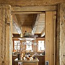 Pour plus de convivialité, la cuisine a été volontairement ouverte sur la salle à manger, entreprise Charmeilles Agencement ; boules de Noël et branches de baies, Sia, au sol, pierre de Bourgogne, Rosset.