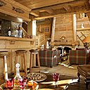 Un même espace ouvert pour le coin  bar et le salon . Un côté bar bas de plafond agrémenté de tabourets recouverts de cuir, Squawvalley, côté salon, canapés Nobilis recouverts de tissus écossais Pietraneck, Squawvalley, menuiserie , entreprise Charmeilles agencement.