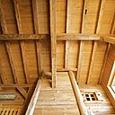 Dominant tout le salon, la hotte de cheminée s’étend jusqu’en haut du premier étage, bois épicéa, architecte, Nicolas Perrin.