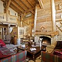 Un mélange de matériaux anciens bois épicéa et pierre pour un espace qui reste cosy . Canapés Nobilis recouverts de tissus écossais, Pietraneck , Squawalley, plaids, Arpin, sur la table basse, vase « Antartic », Sia et vase à plusieurs branches, Coming, B.