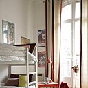 Dans la chambre des enfants, un lit superposé recouvert de couettes, Caravane, tapis, Casa Lopez, lampe canard, coussins, Maison de Vacances, bureau et chaise rouge, Ikea repeintes avec une peinture de chez Ressources.
