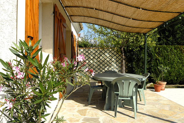 une terrasse avec une  tonnelle