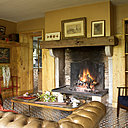 A l’heure du thé, devant la grande cheminée d’époque : un confortable  Chesterfield, village Notre Dame, une table basse, Thonet, fauteuil, Morris, sur la gauche, une petite console rouge, RKR, au-dessus, tableau de broderies anglo-saxonnes (1940), sur la cheminée, de gauche à droite, tableaux de G.Valmier, orientaliste anonyme du XIXème, portrait chinois (1941).