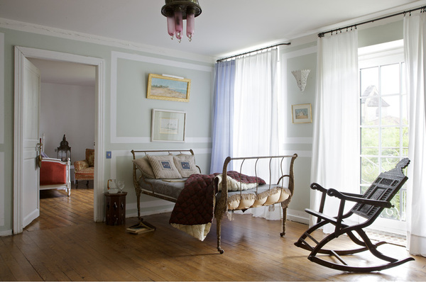 Une chambre sous le signe de l’orientalisme ; lit chiné, Village Notre Dame, table basse et fauteuil à bascule, souk de Tanger, tableaux orientalistes, coussins Lesage, couvre lit Naaj, CSAO,  rideaux, Ikea
